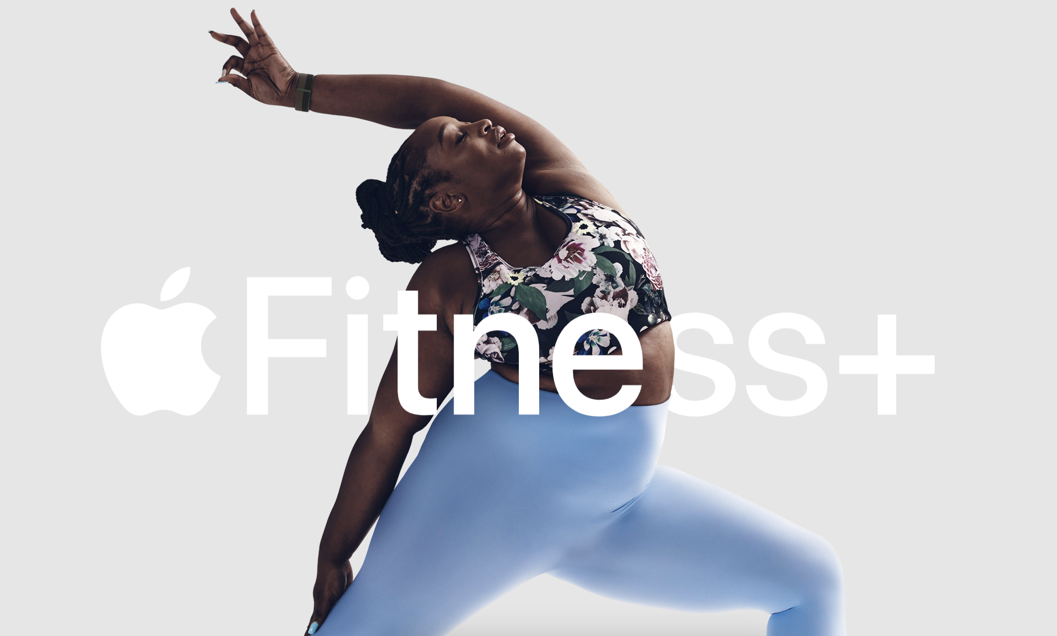 person stretching into a yoga pose with the logo for apple fitness plus in front of them