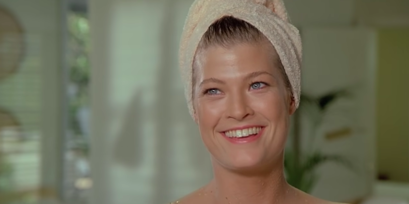 Woman smiling with a towel wrapped around her head.
