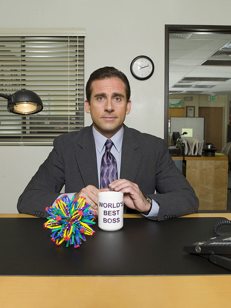 Michael Scott posing with his world&#x27;s best boss mug