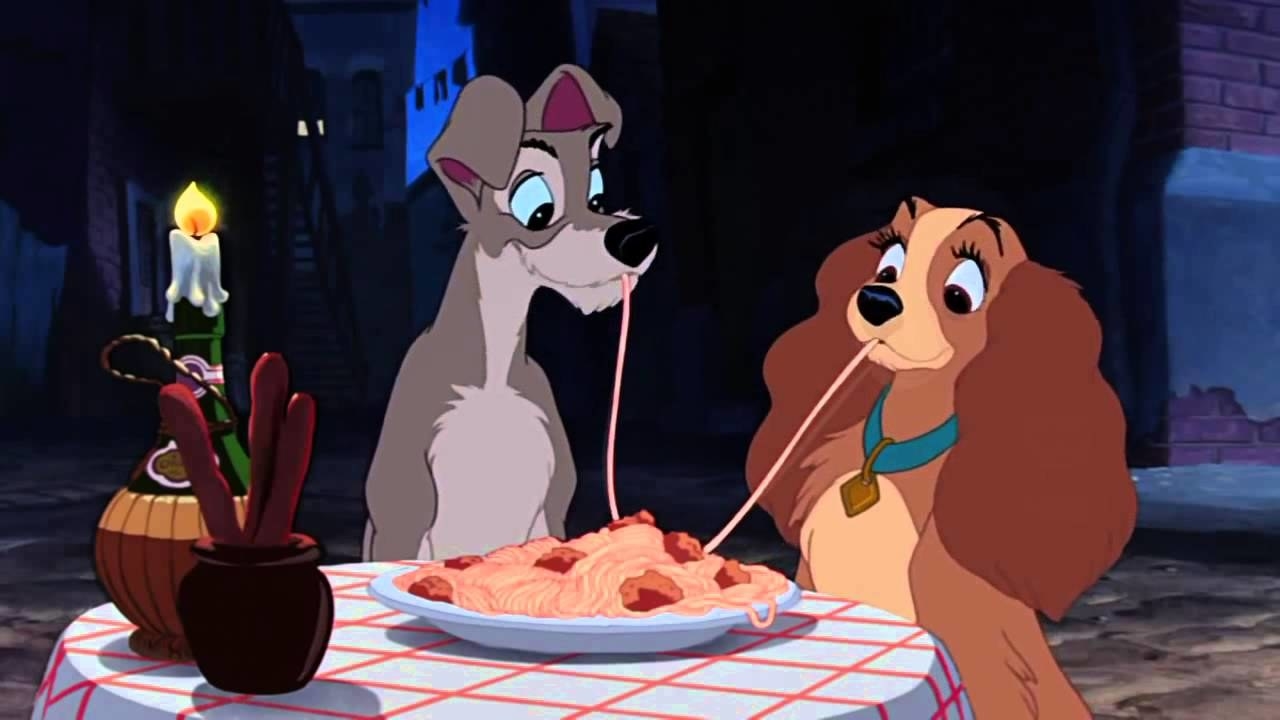 Two cartoon dogs sharing a plate of spaghetti