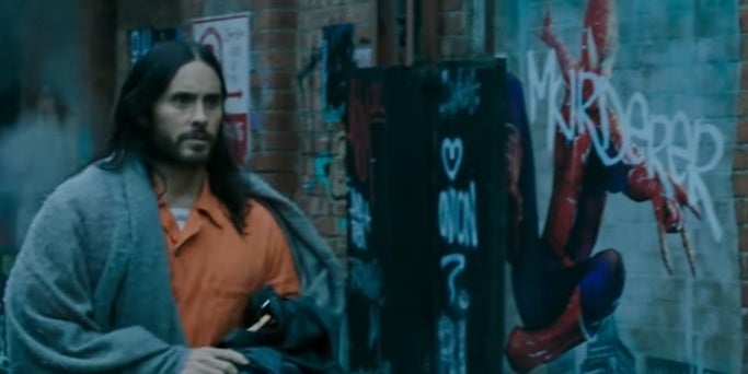 Morbius walking down an alley and passing a grafitti painting of Spider-Man in "Morbius"