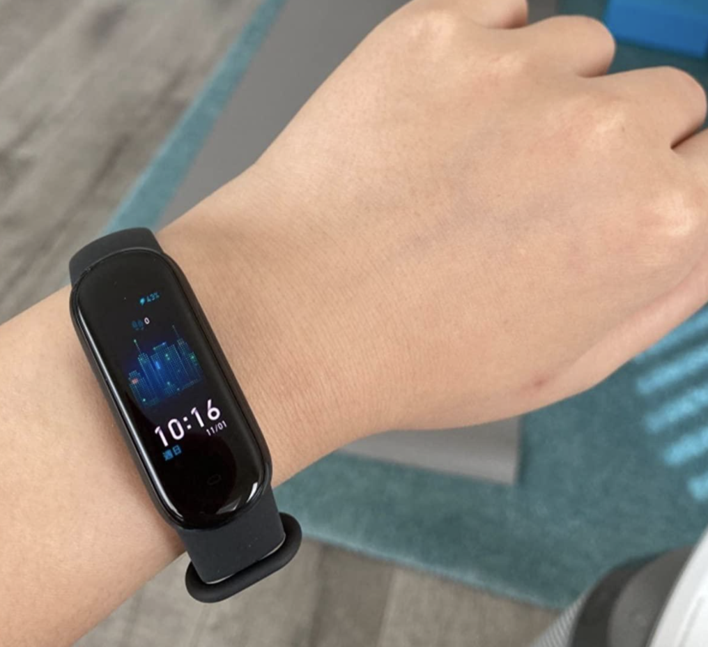 A reviewer wearing the fitness tracker in black
