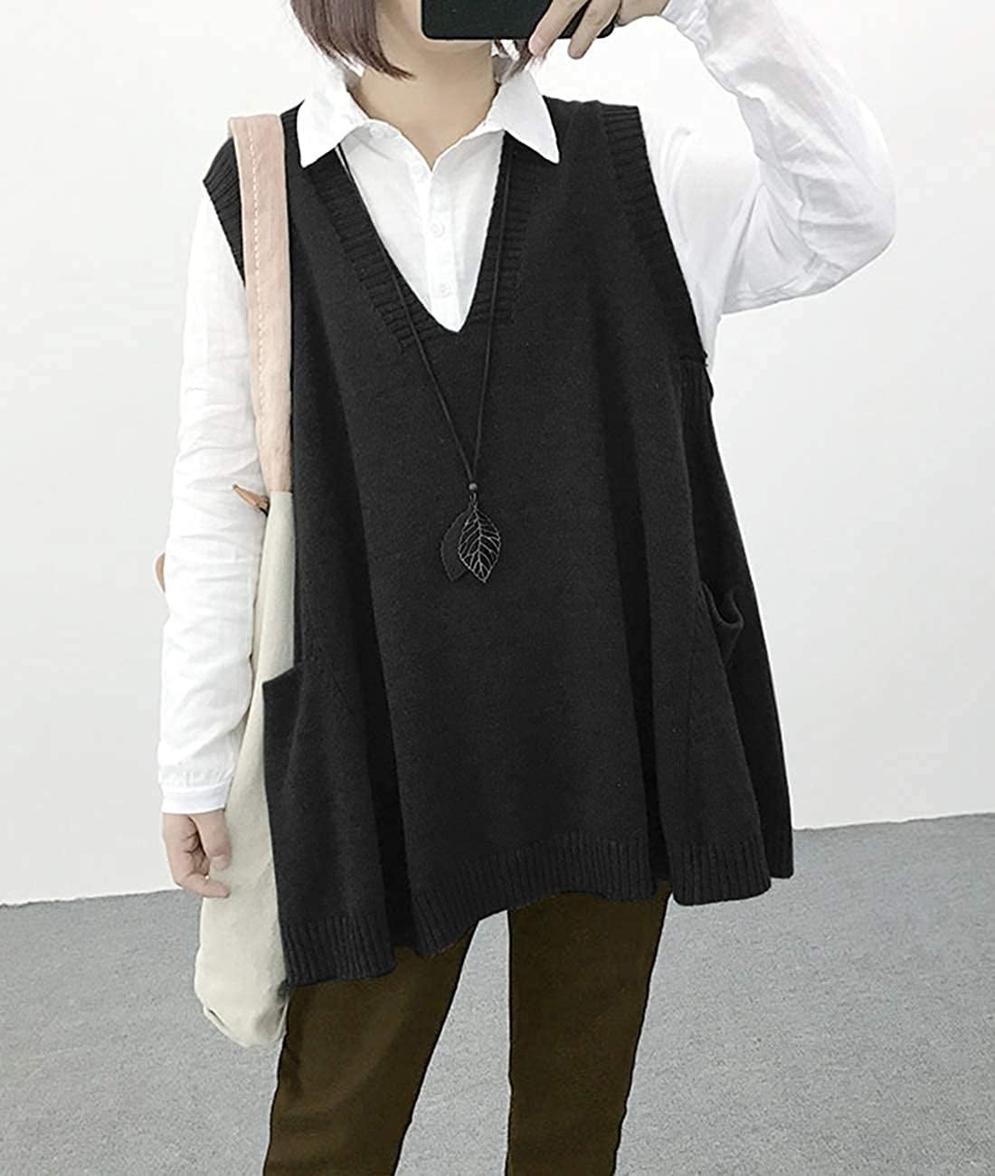 A model wearing the oversized gray sweater vest over a white button down