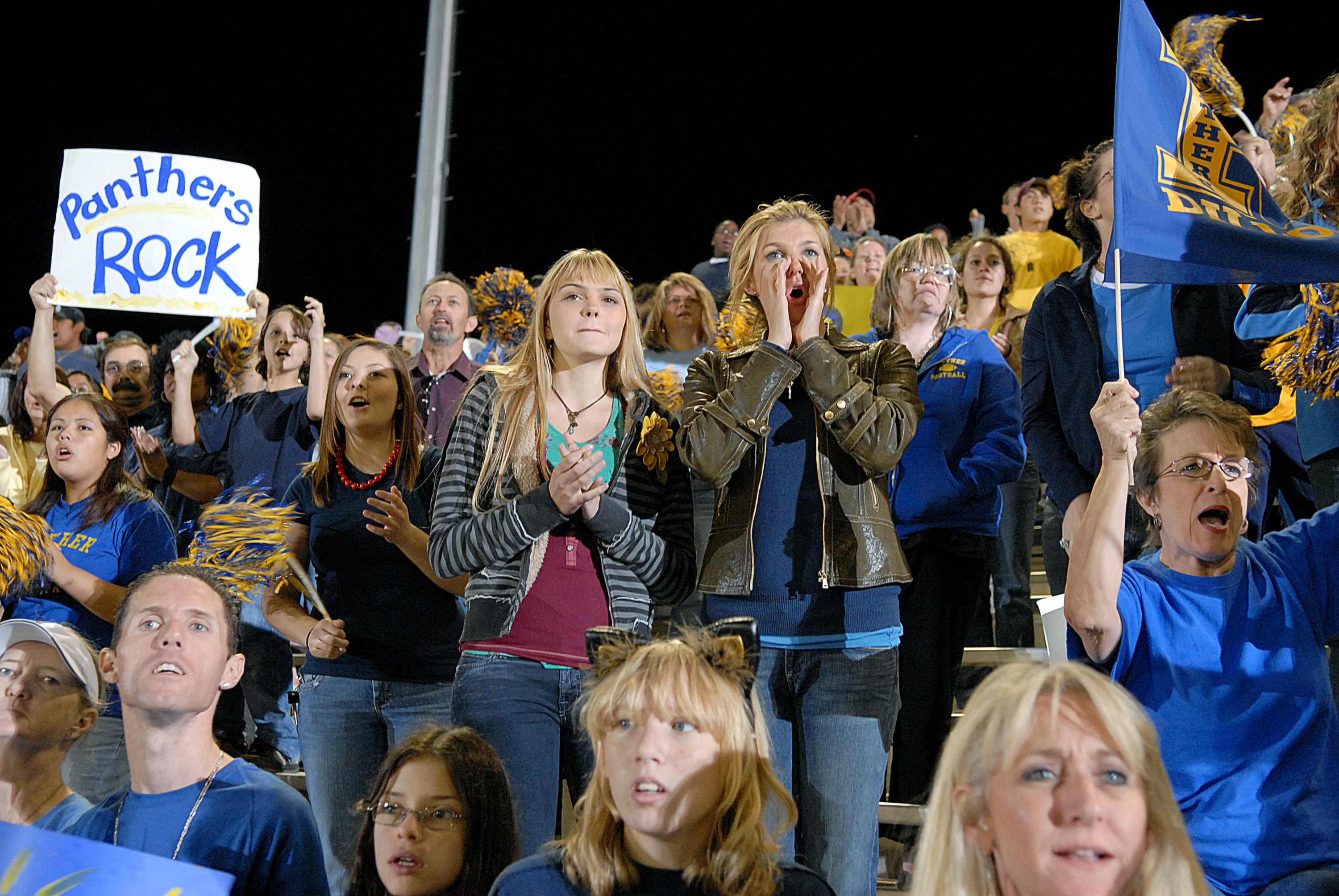 Fans, Tami included, cheering in the stands during a game