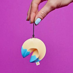 a fortune cooking toy hanging from a hand