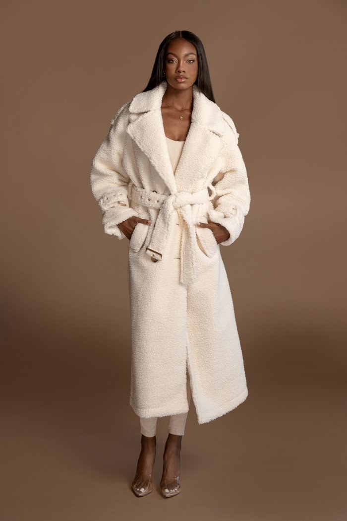 model wearing a long teddy coat that hits model mid shin