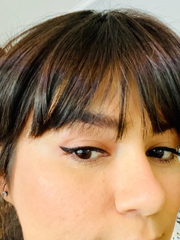 reviewer wears cat-eye look created with the winged eyeliner stamp above
