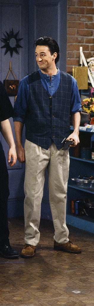 Chandler wearing pants, a long shirt, and a vest