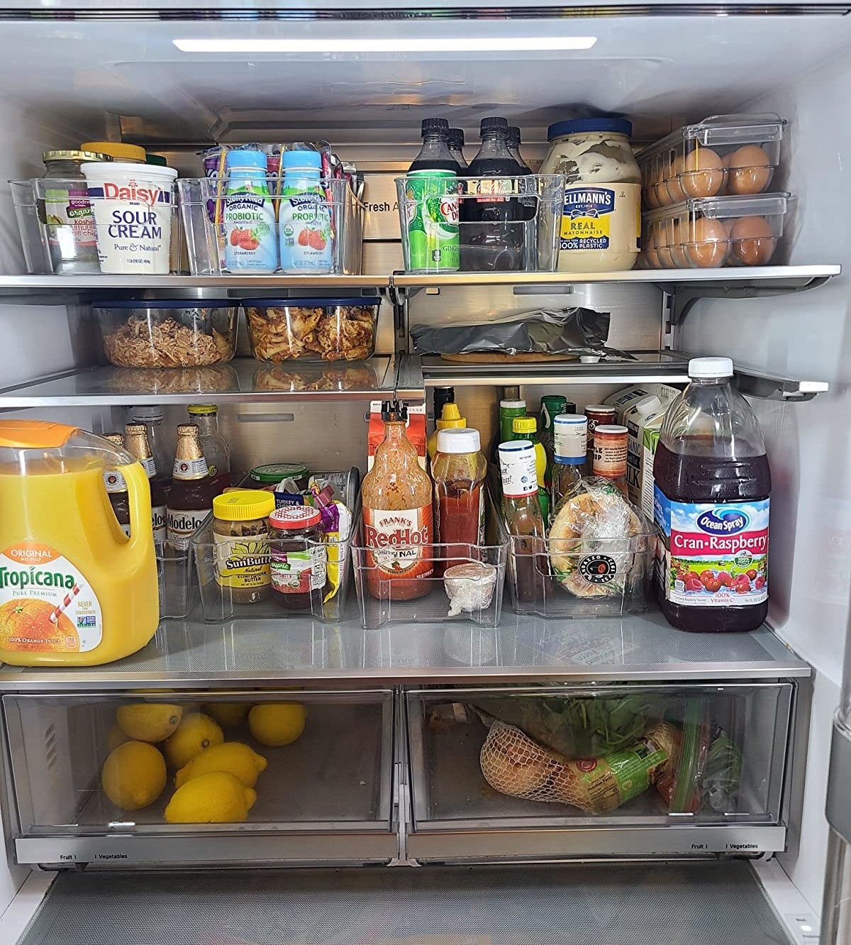 Reviewer photo of the organizers being used to hold groceries in a very tidy fridge