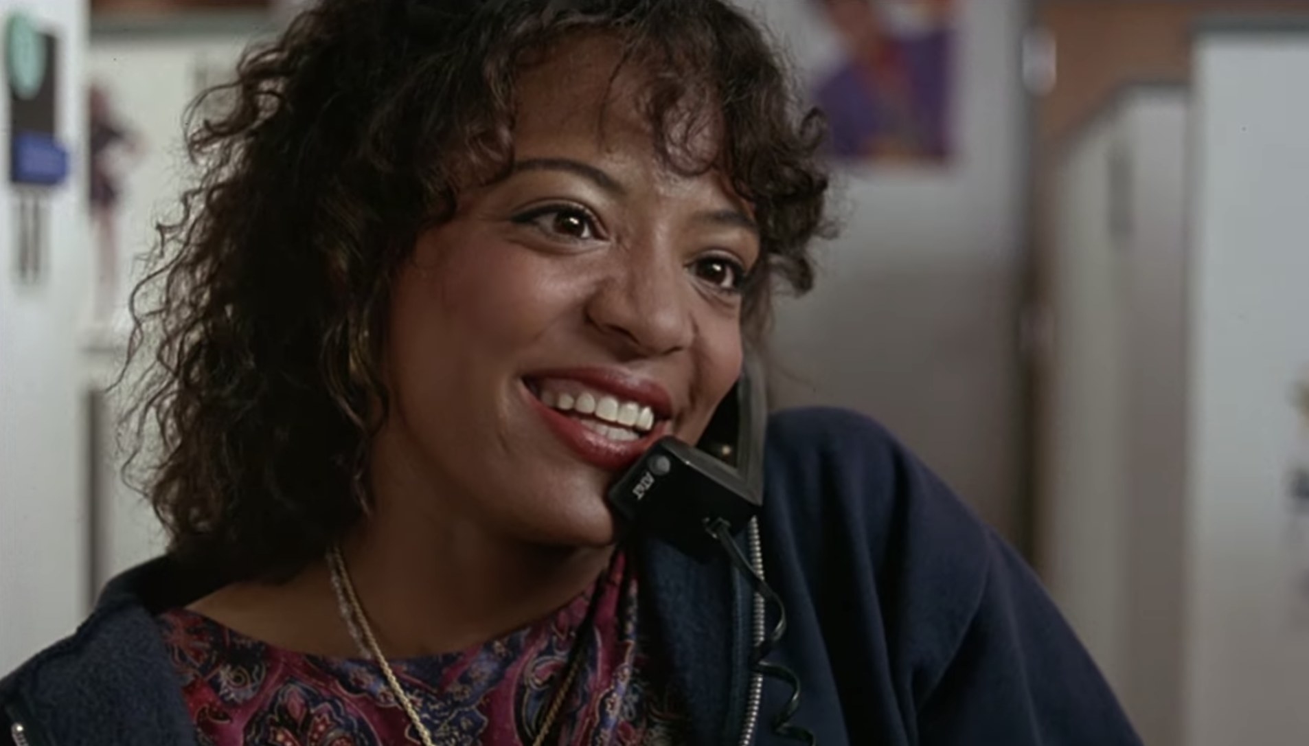 Lauren Vélez smiles while holding a telephone to her ear in the movie.