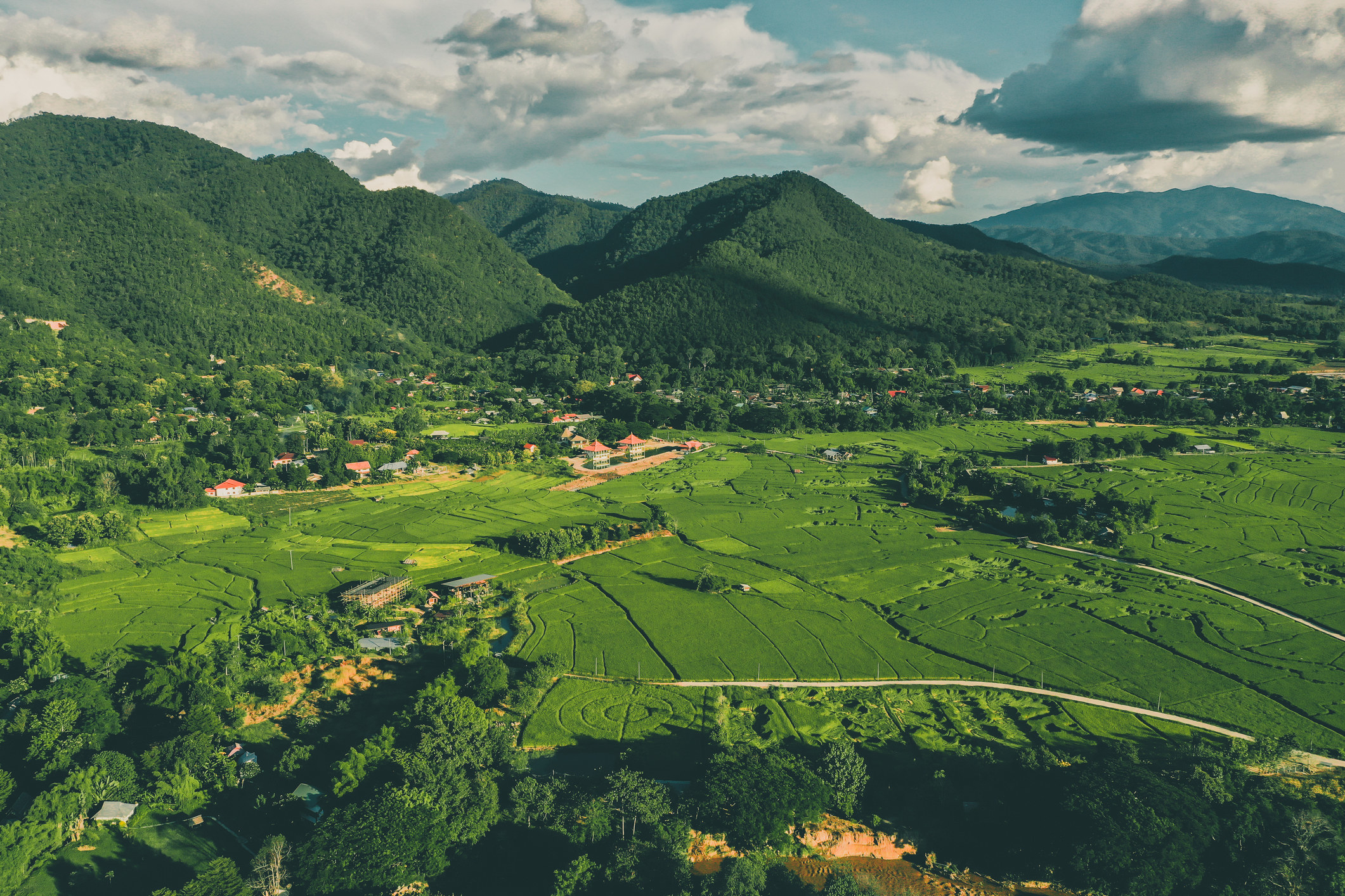 Aerial view of Pai rice terraces, river and mountains.