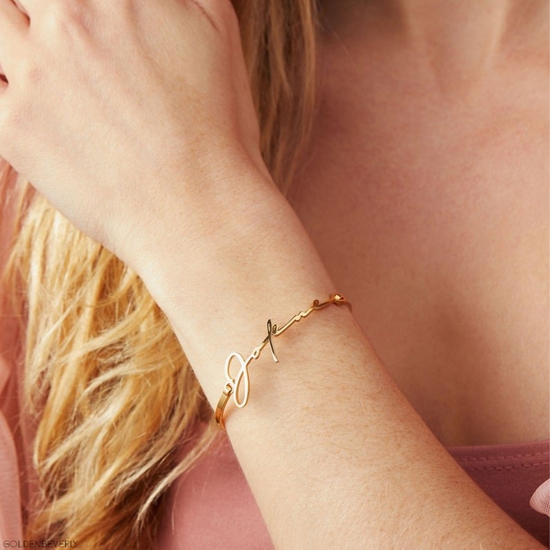 person wearing bangle that has a signature on it