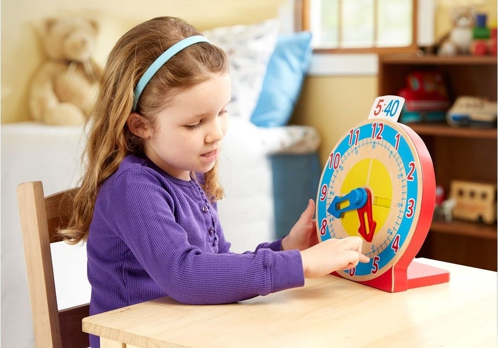 child playing with the clock toy