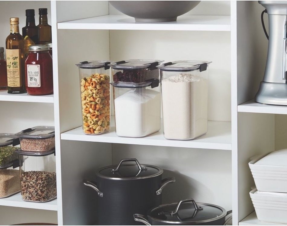 different sized food storage containers with dried goods inside, on a shelf