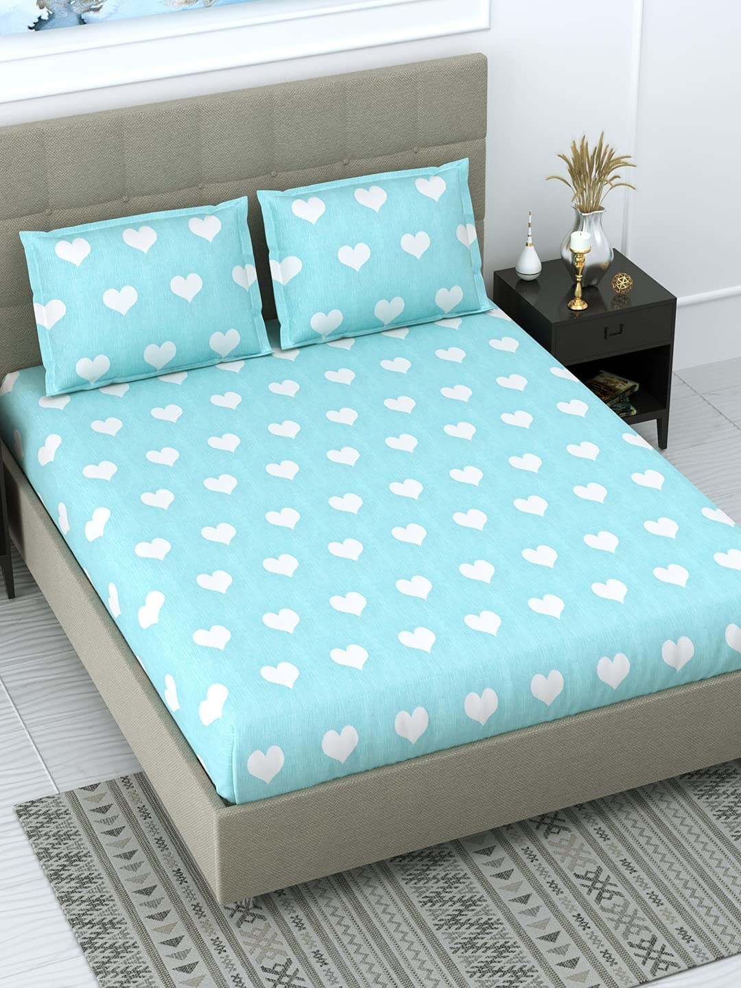A blue bedsheet with white hearts on it