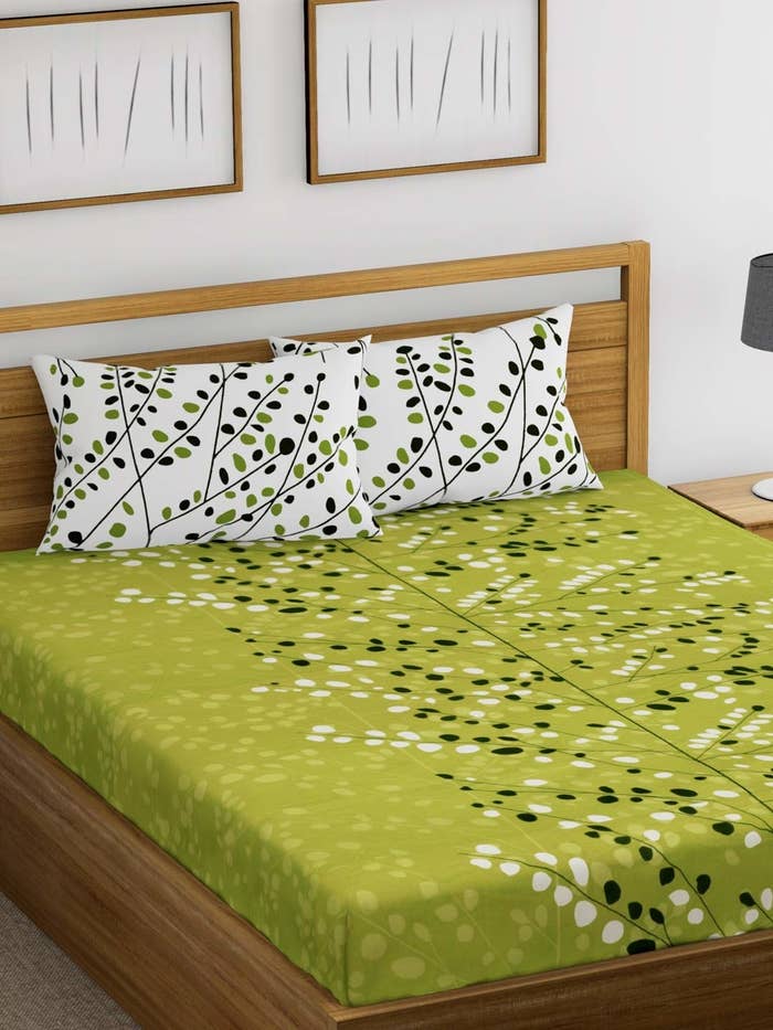 A green black and white bedsheet with vines on it