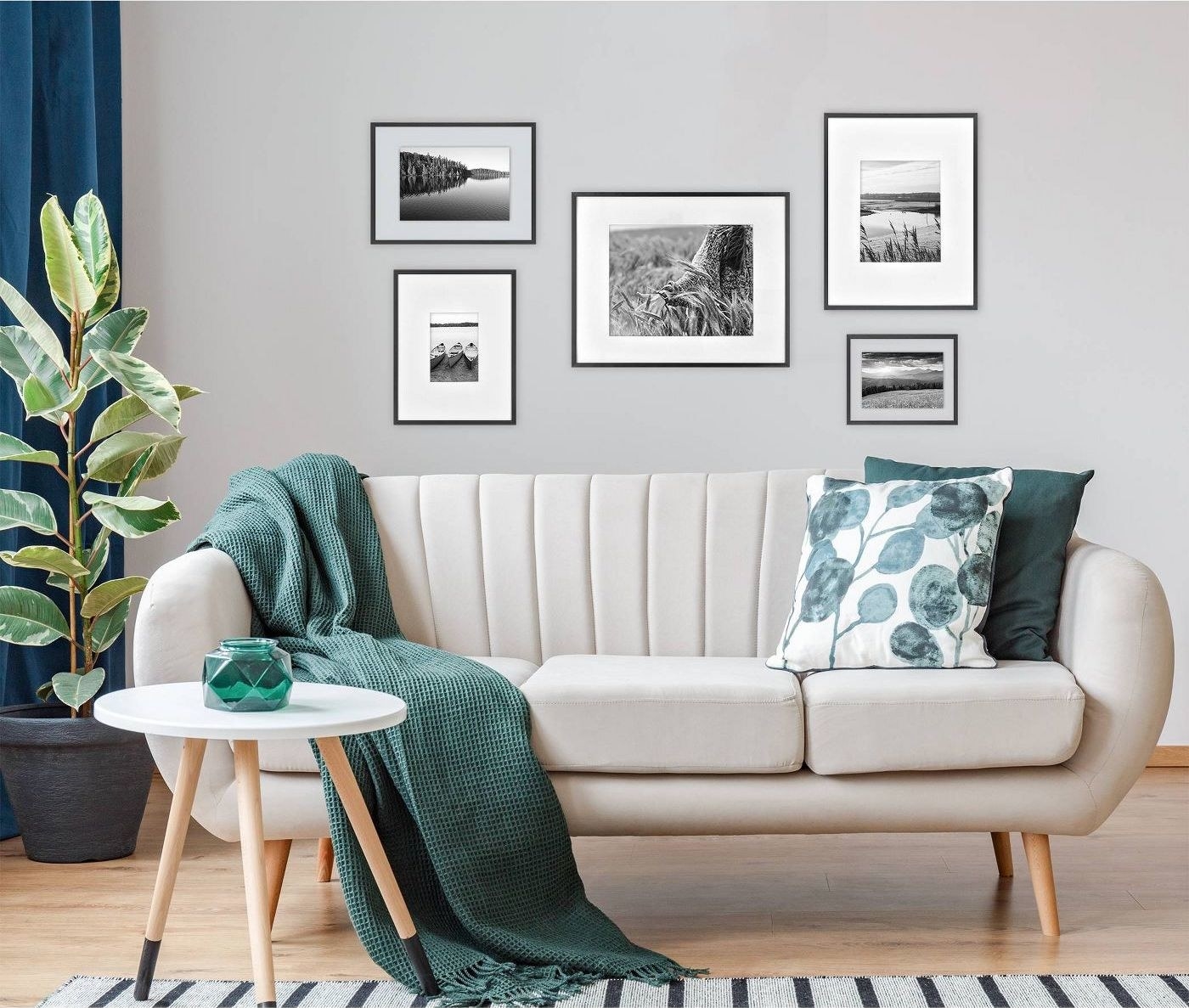 five black frames on a wall with black and white photographs inside, in back of a white couch