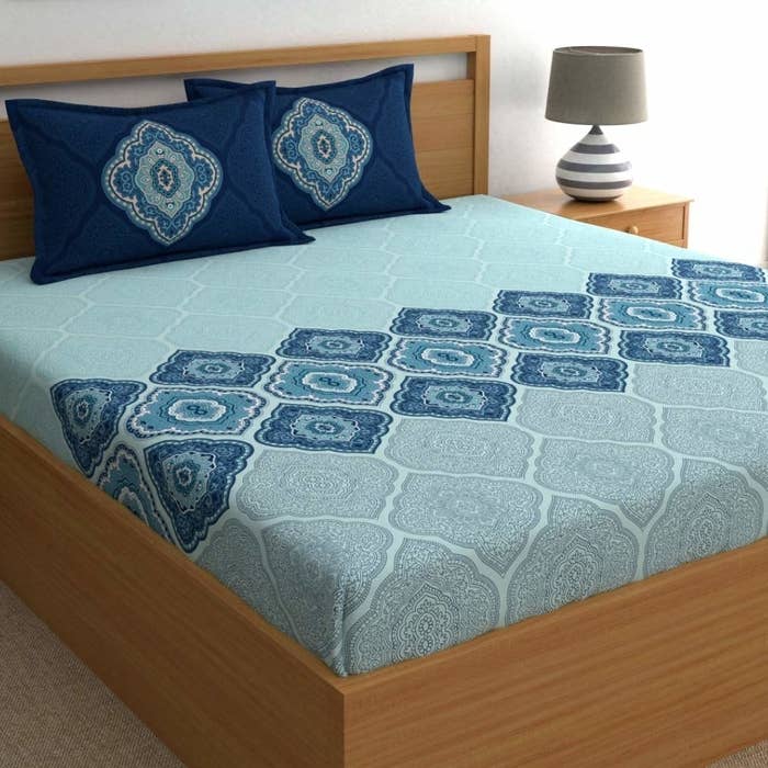 A light and dark blue bedsheet on a bed