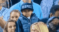A little boy takes off his hat as a sign of respect