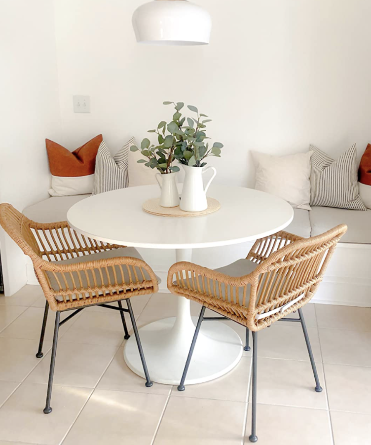 a reviewer photo of two rattan chairs at a white table