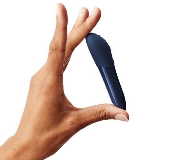 A hand holding the vibrator in blue
