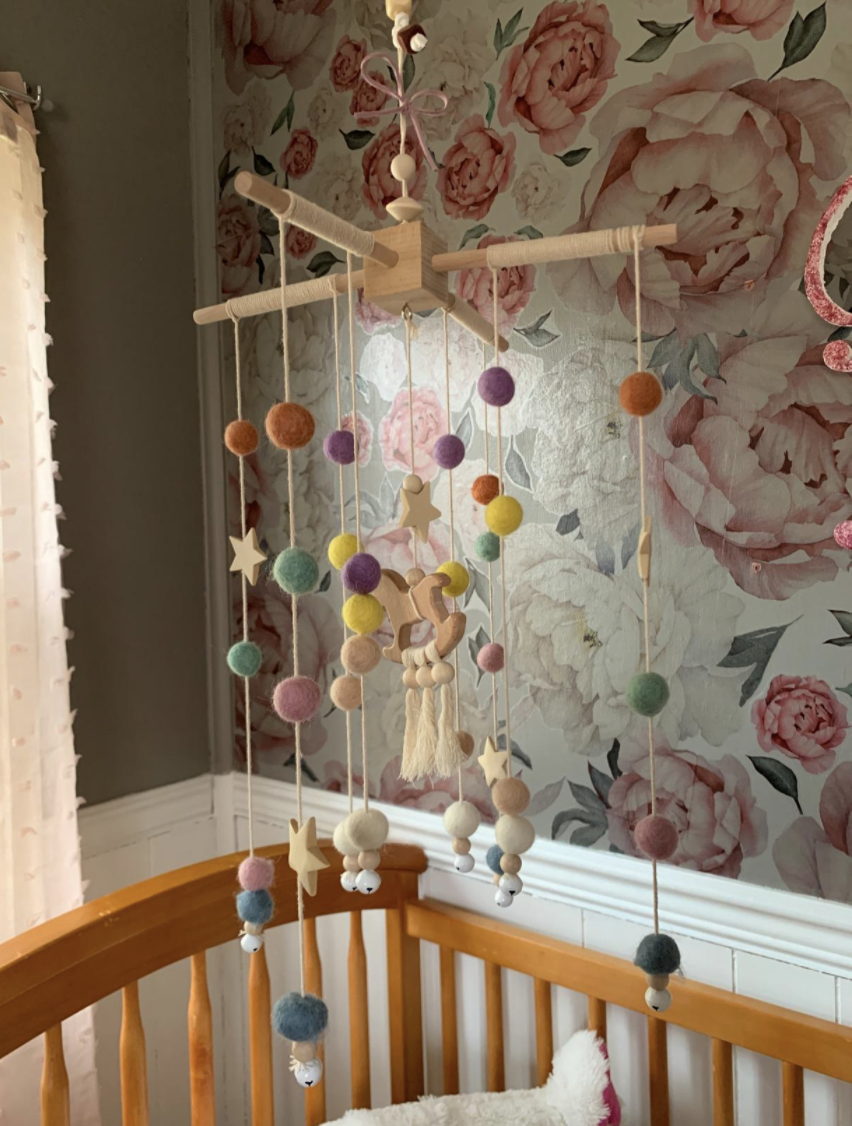 a reviewer photo of the mobile over a crib