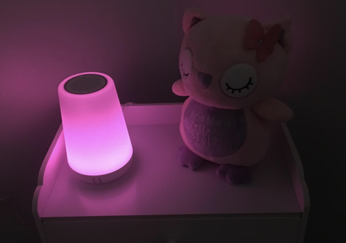 a reviewer photo of the nightlight sound machine next to a stuffed animal