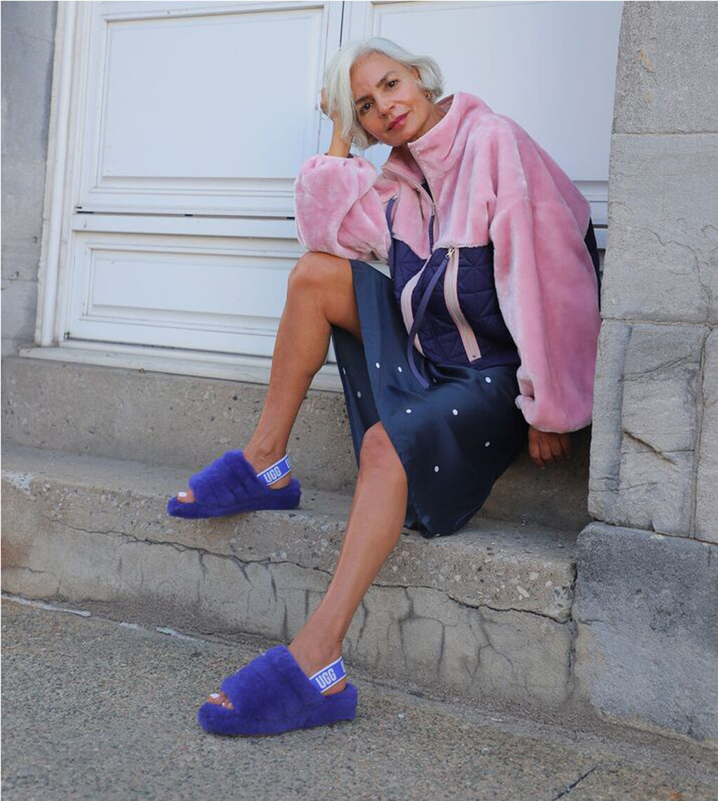 a model wearing the ugg slides in purple