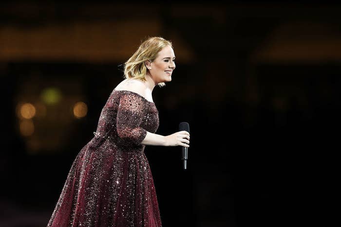 Adele smiles as she stands onstage