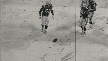 Leon Lett slides and kicks spinning football on a snow-covered field