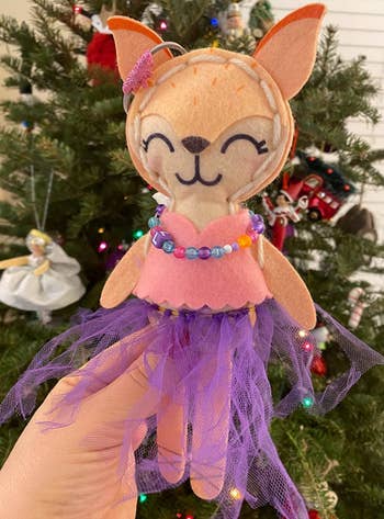 the finished fox wearing a purple tutu, beaded necklace, and pink top with a scalloped hem