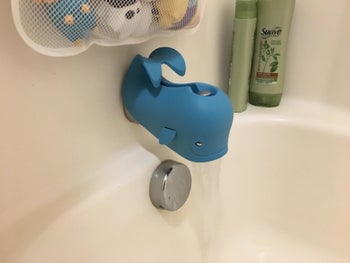 reviewer's photo showing the blue whale covering bath faucet
