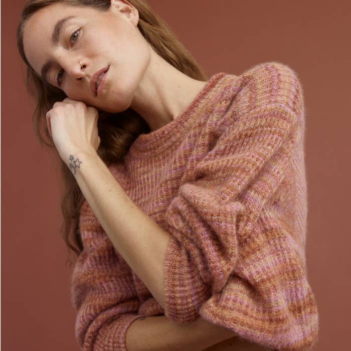a model wearing the oversized crewneck sweater in a red tonal color