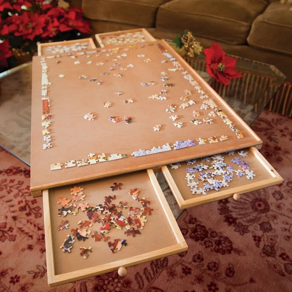 a puzzle being completed on the board with pieces in the drawers