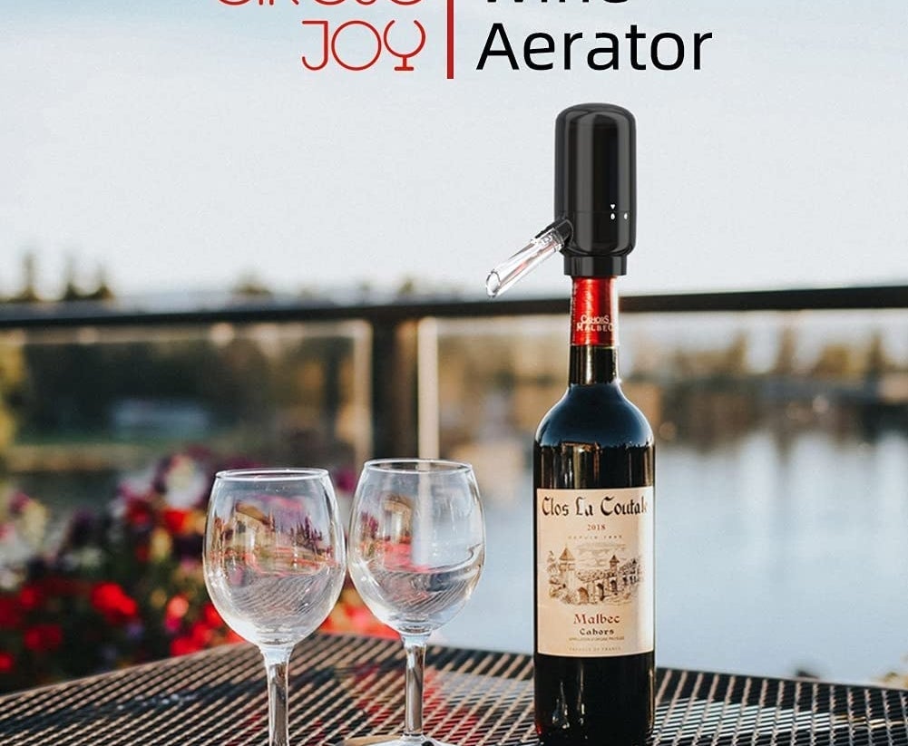 the wine aerator on a table with two wine glasses