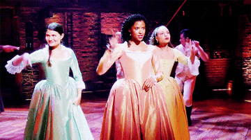 angelica, peggy, and eliza from hamilton dancing on stage