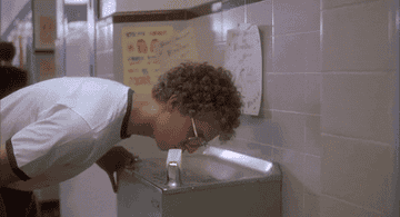gif of jon heder as napoleon dynamite looking up from a drinking fountain