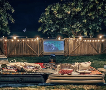 reviewer's backyard with a screen set up and the projector playing a movie