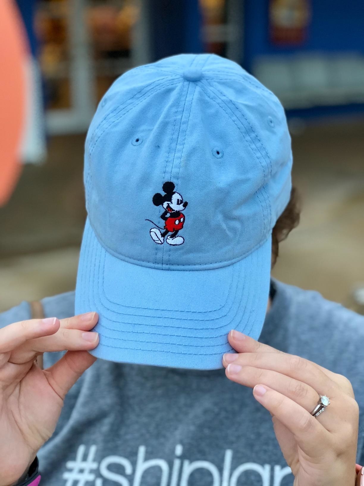 a reviewer tipping the hat down in light blue with mickey on it
