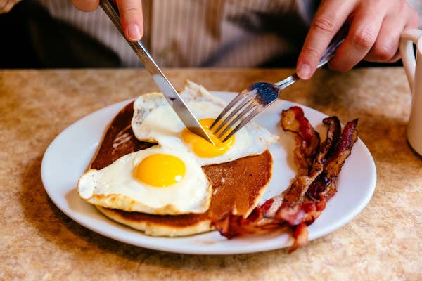 Pancakes, bacon, and eggs on a plate.