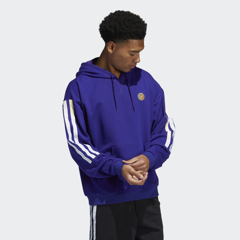 A model wearing the purple drawstring hoodie with white 3-stripe sleeves