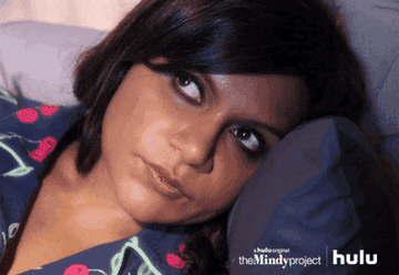 GIF woman in bed looking around