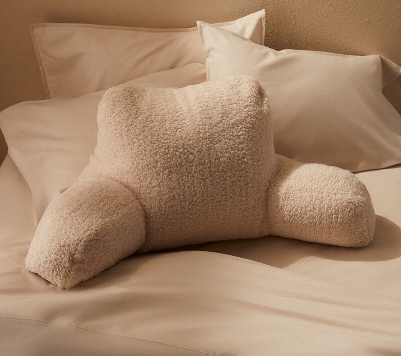 a cozy sherpa back pillow with armrests