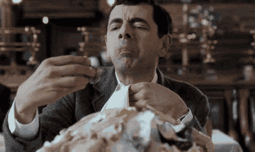 mr bean sat in a restaurant about to eat an oyster