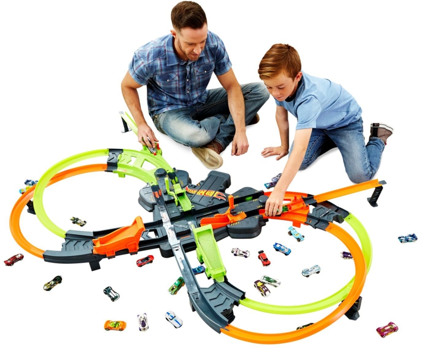 a parent and child playing with the hot wheels track
