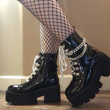 Reviewer wearing black platform combat boots with fishnet tights