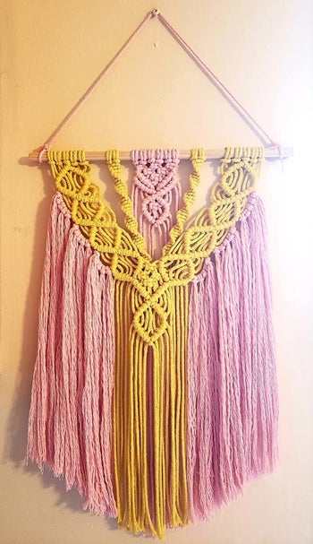 reviewer image of pink and yellow macrame hanging from wall