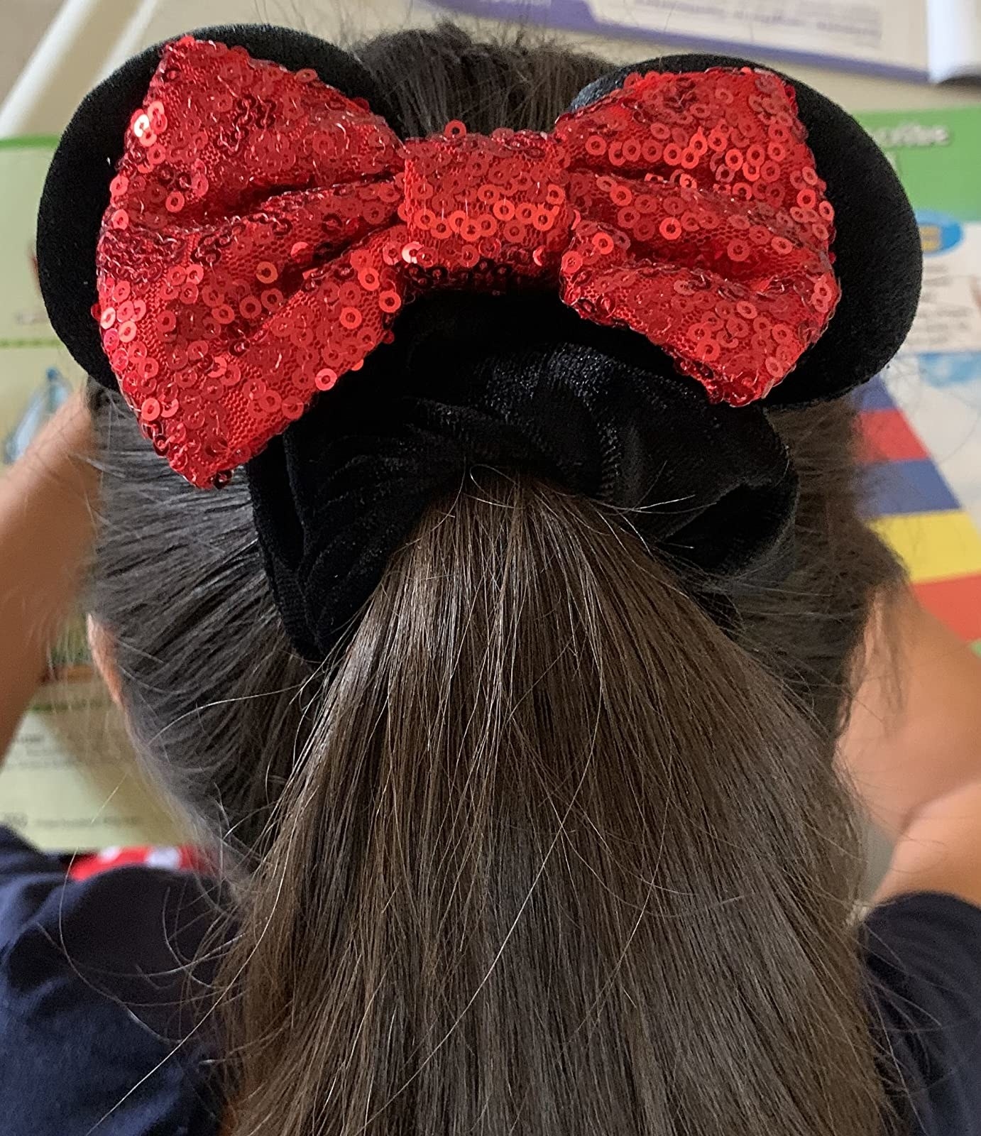a reviewer with the minnie mouse ear scrunchie in their hair