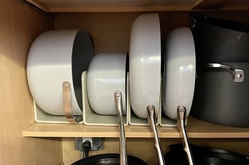 pans and pots placed in the magnetic racks in writer Kayla's cabinet