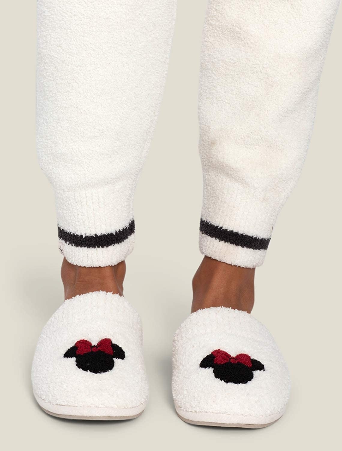 white fluffy slippers with an icon of minnie mouse on them